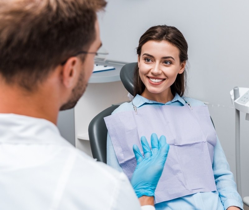 Woman smiling at dentist during dental checkup and teeth cleaning visit