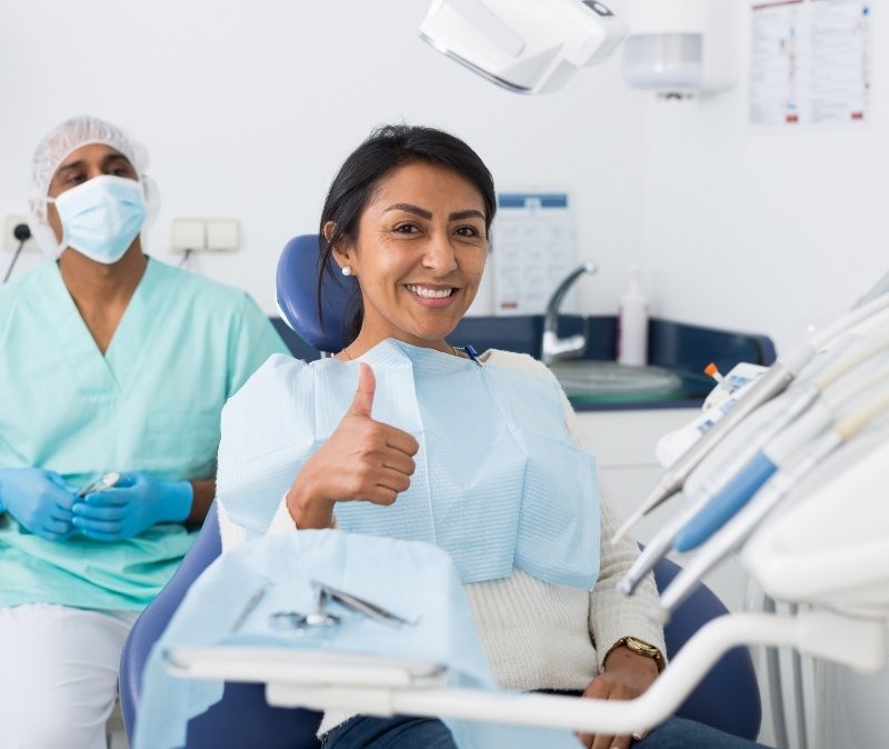 Woman giving thumbs up after gum disease treatment