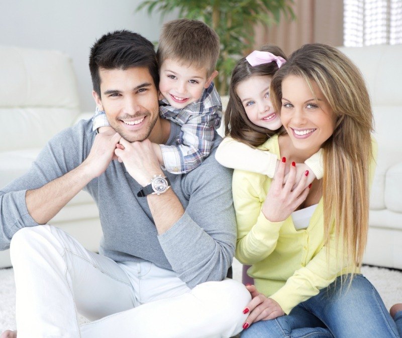 Smiling parents and children after family dentistry