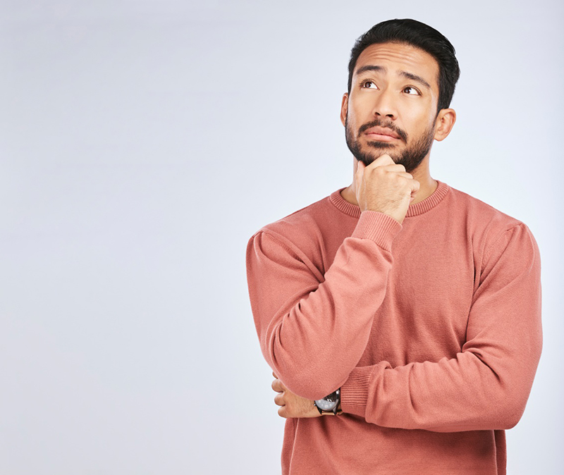 Man deep in thought, pictured against neutral background