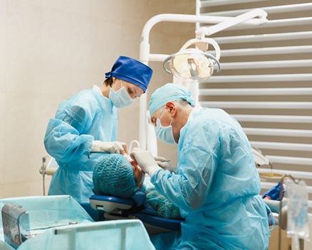 Dental team carefully performing oral surgery