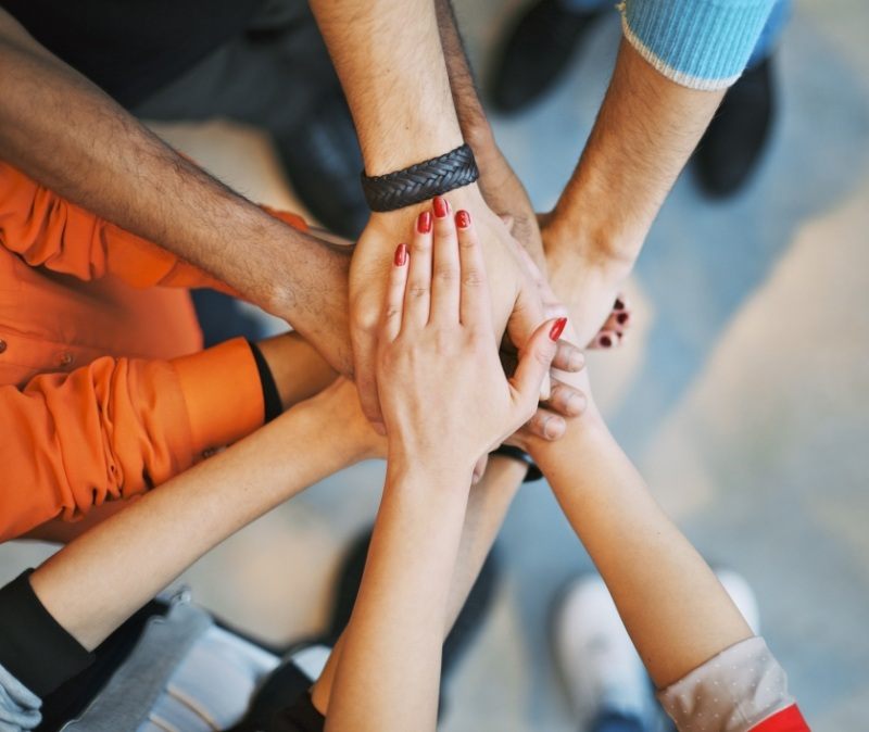 Group of people putting their hands together