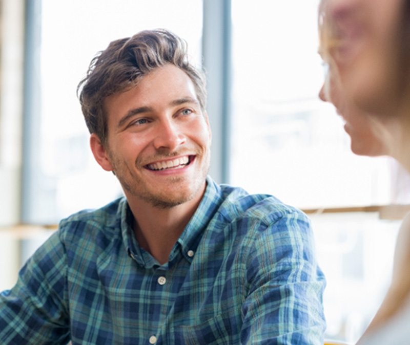 man smiling while talking to woman