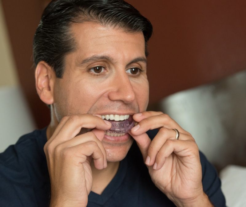 Man placing a CPAP alternative oral appliance