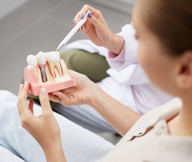 Dentist and dental patient looking at dental implant supported dental crown