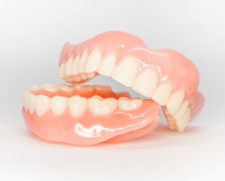 Full dentures pictured against neutral background