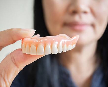 Close-up of woman holding her upper denture