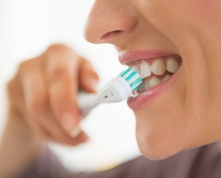 Dental patient brushing teeth to maintain good oral hygiene