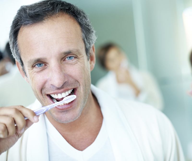 Man brushing teeth to prevent gum disease
