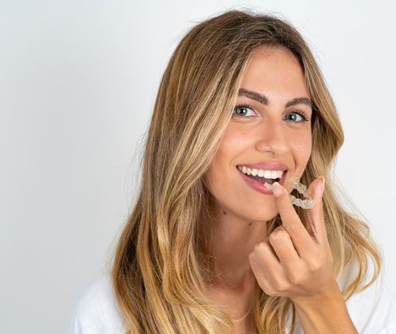 Attractive woman holding Invisalign aligner