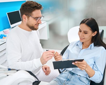 Dental patient holding clipboard, signing a document