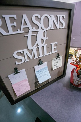 Reasons to smile sign on dental office reception desk