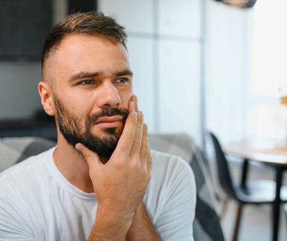 Concerned man holding the side of his face