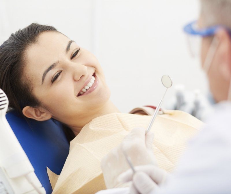 Dentist examining dental patient after full smile makeover