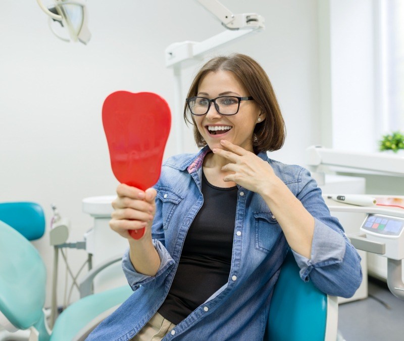 Woman looking at smile after makeover