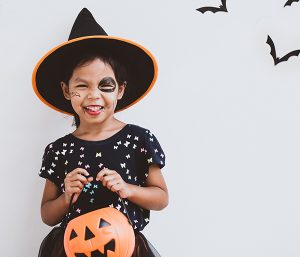 girl in costume holding pumpkin