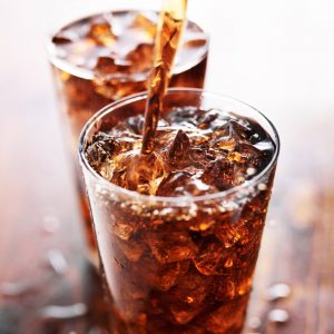 A diet soda being poured into a glass.