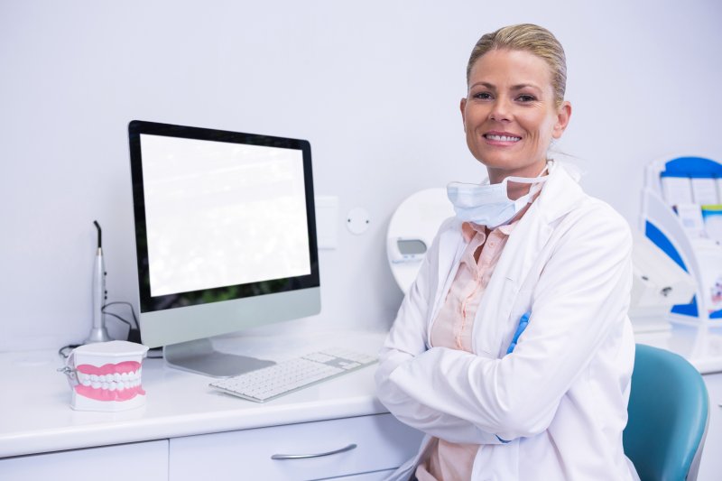 Cosmetic dentist smiling and folding her arms.