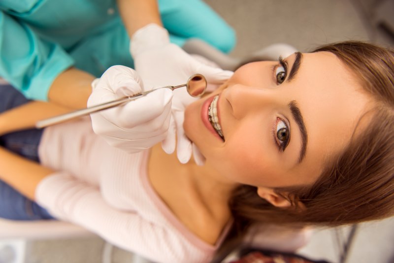 Woman wearing traditional braces during her routine exam