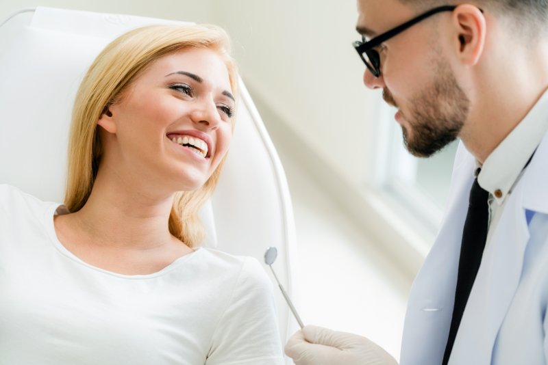 Dentist explaining the difference between veneers and bonding to patient