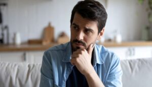 Concerned man touching the side of his face 
