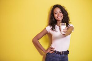 Happy woman holding a glass of milk