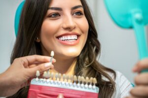 Happy patient looking at her teeth in mirror